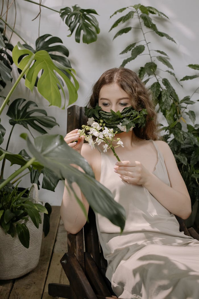 A Woman in Brown Sleeveless Dress Holding White Flowers